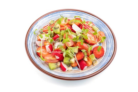 Vegetarian fruits and vegetables salad of strawberry, kiwi, tomatoes, microgreen sprouts isolated