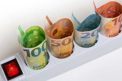Symbolic image of electricity costs: Multiple socket outlet with banknotes