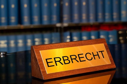Symbolic image of inheritance law: Brass sign with the inscription Erbrecht in front of a large