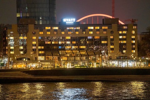 The Hyatt Regency Hotel on the Rhine, in Cologne Deutz, behind it the illuminated arch of the