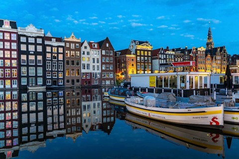 Canal houses on the Damrak, in the centre of the old town of Amsterdam, harbour, starting point of