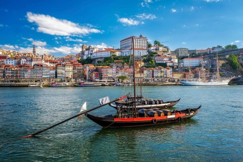 View of Porto city and Douro river with traditional boats with port wine barrels and sailing ship