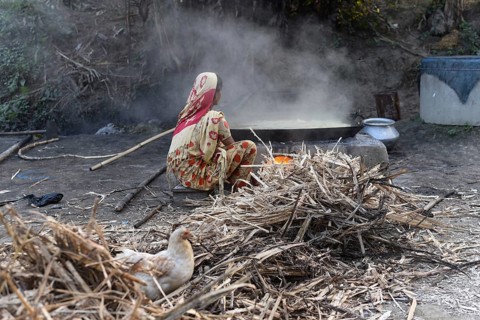 Workers boiling sugarcane juice as they are making Gur (jaggery) in a village on December 10, 2021
