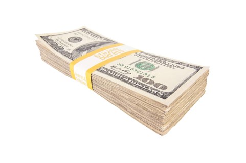 Stack of ten thousand dollars worth of one hundred dollar bills isolated on white background