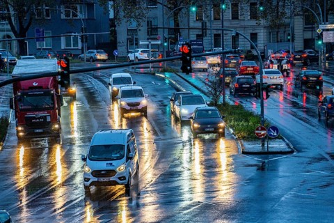 Rainy weather, road traffic, intersection, lights of vehicles on a wet road, traffic lights, tail