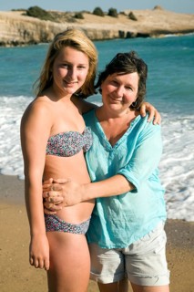 Model released mother and daughter embrace on holiday at the beach, Rhodes, Greece, Europe