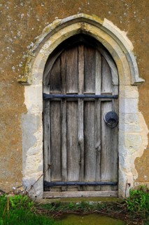 Small doorway wooden door into Ramsholt church, Suffolk, England, UK