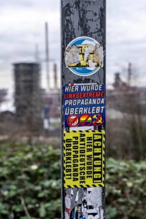 Stickers of right-wing extremist groups pasted over stickers of apparently left-wing groups,