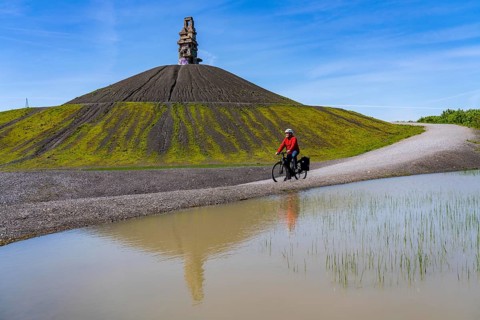 Cyclist on the Rheinelbe spoil tip in Gelsenkirchen, 100 metre high spoil tip, landscape park, with