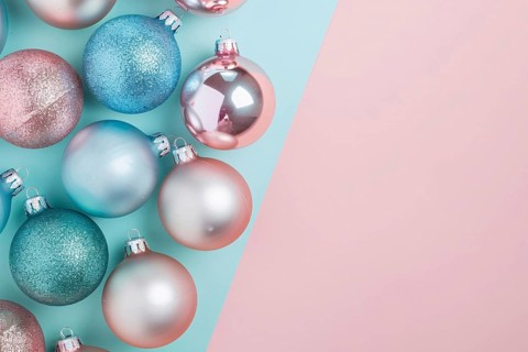 Christmas flatlay with blue and pink colored tree baubles on pastel background with copy space.