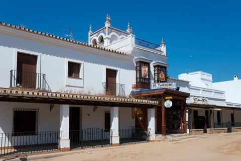 Ein traditionelles, weißes Gebäude im spanischen Stil mit Balkonen unter einem klaren, blauen