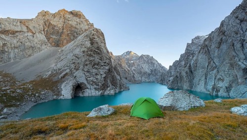Wild camping, camping in the wilderness with a tent in front of mountain lake Kol Suu, Sary Beles