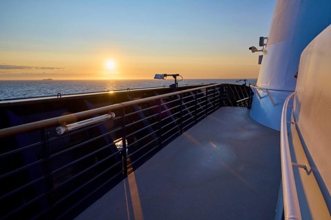 Deck of a ship at sunrise with clear sky and blue railing, Mein Schiff 6, North Sea, Denmark,