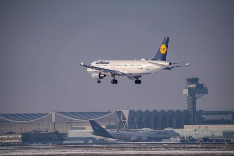 Lufthansa Airbus A320-200 approaching Frankfurt FRA airport, air traffic control tower, Fraport, in