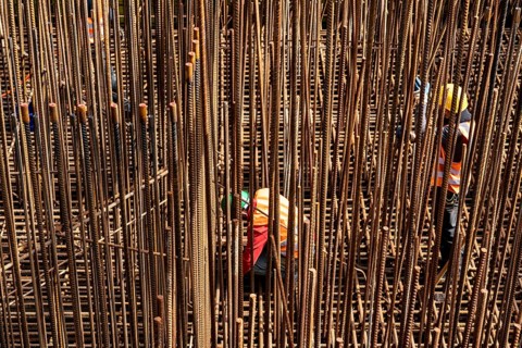 Construction site, reinforced concrete construction site, workers erect a mesh of reinforcing bars,