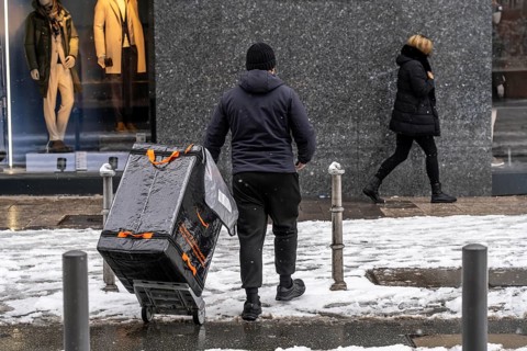 Winter in Frankfurt, Amazon delivery employee brings a shipment to the customer, on foot, in the