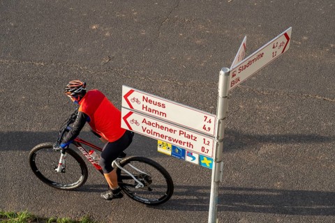 Cyclists on a path, Rhine embankment path, signpost for cyclists, Düsseldorf, North