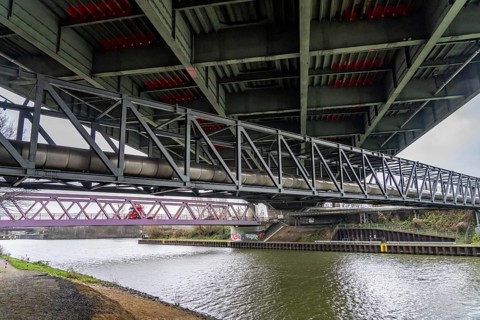 Dilapidated A42 motorway bridge (red arches) over the Rhine-Herne Canal, with massive structural