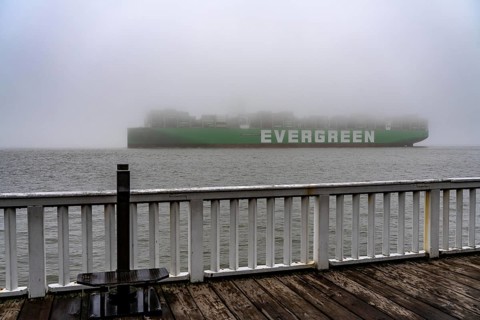 Thick fog in winter, hanging over the mouth of the Elbe into the North Sea, container ship Ever
