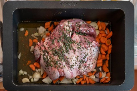 Roast lamb with herbs and vegetables in a casserole in front of roasting, Bavaria, Germany, Europe