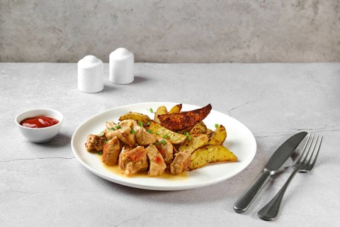 Beef goulash with baked potato wedges on a plate
