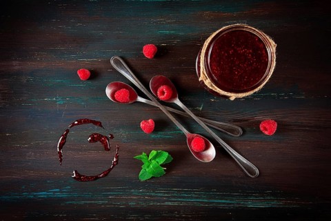 Raspberry jam, on a dark wooden background, top view, selective focus, food concept, no people