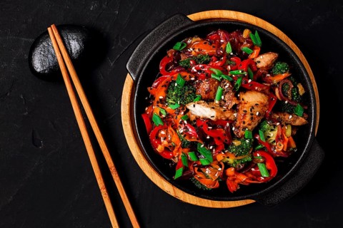 Asian cuisine, teriyaki meat with vegetables, in a cast-iron frying pan, close-up, no people