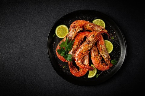 Langoustines, Australian, freshly frozen on ice, top view, lime and greens