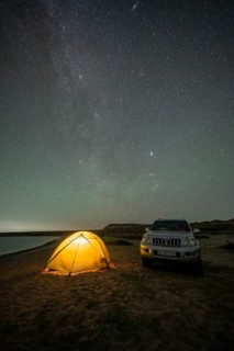 Off-road vehicle and tent, night shot, Milky Way at Lake Issyk Kul, Kyrgyzstan, Asia