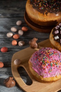 Homemade glazed and decorated easter pies with chocolate eggs and rabbits on a gray wooden