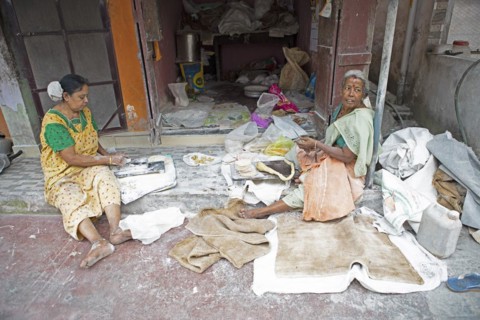 Indian woman making pappadam or Indian bread on the footpath, Kochi, Kerala, India, Asia