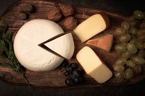 Georgian cheese, Imeretian and smoked suluguni, grapes, nuts, on a cutting board, Georgian cuisine,