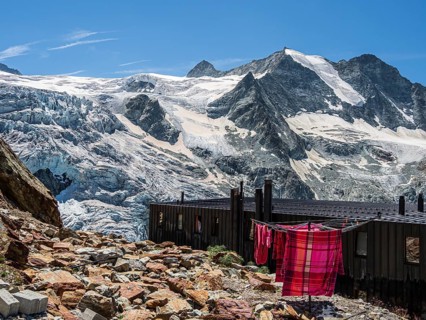 Colored bed linen dries in the sun, mountain hut Cabane de Moiry, located close to the retreating