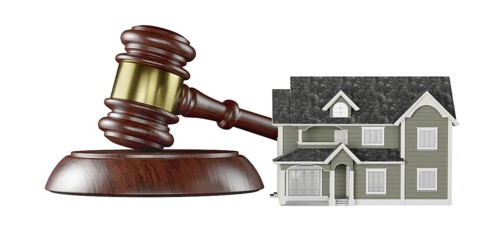 Wooden gavel and miniature house isolated on a white background