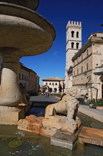 Piazza del Comune market square, fountain and church of Santa Maria sopra Minerva in Assisi,