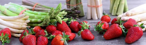 Green asparagus, white asparagus and fresh strawberries decorated on a rustic wooden table