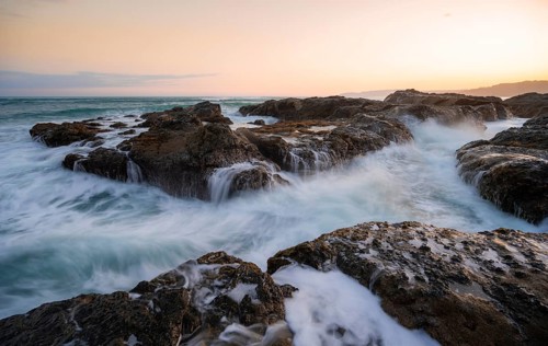 Waves washing over rocks by the sea, long exposure, coastal landscape at sunset, Playa Cocalito,