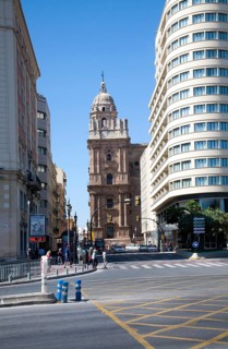 Historic cathedral framed by modern buildings, Malaga, Spain viewed up Molino Laria street