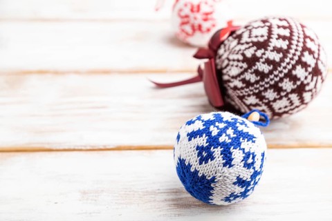 Christmas or New Year composition. Decorations, knitted balls, on a white wooden background. Side