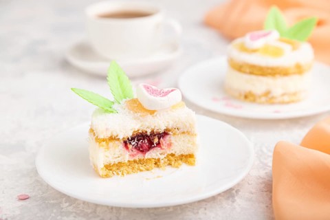 Decorated cake with milk and coconut cream with cup of coffee on a gray concrete background and