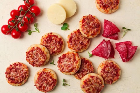 Mini pizzas, salami with mozzarella cheese, on a white table, top view, no people