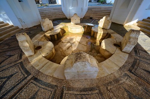 Circular stone fountain with several seats and a stone floor, thermal springs, thermal baths,