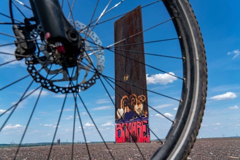 Cycling in the Ruhr area, on the Schurenbach slag heap, Bramme landmark for the Ruhr area by artist