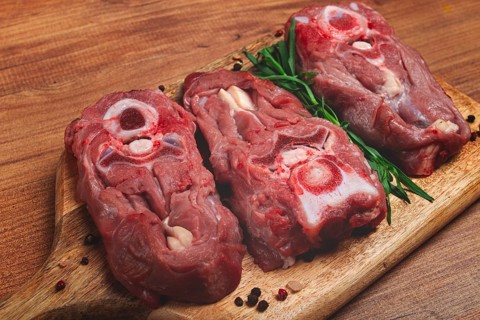 Raw steak, calf's neck on the bone, fresh meat, on the cutting board, top view, no people