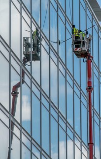 Window cleaner, building maintenance, facade cleaning, on a cherry picker, in Düsseldorf, North