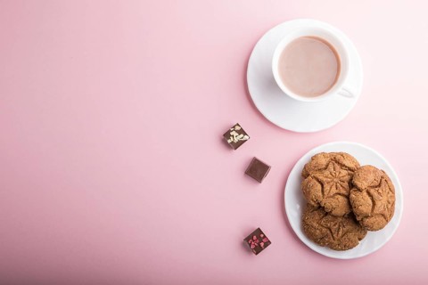 Homemade oatmeal cookies with a cup of cocoa on a pink pastel background. top view, flat lay, copy