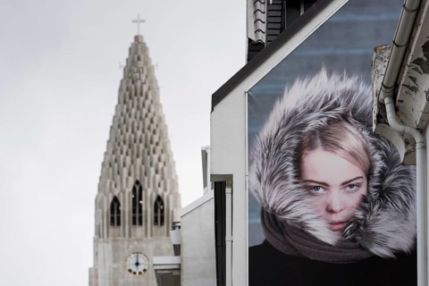 Advertisement on house wall, Hallgrimskirkja or church of Hallgrímur, landmark of Reykjavík,