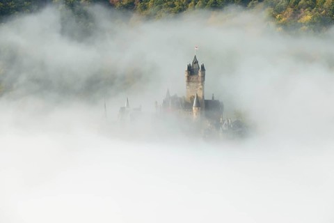 View of the Reichsburg castle near Cochem in dense fog, Moselle, Rhineland-Palatinate, Germany,