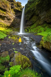 Tourist at Kvernufoss waterfall, in summer when the weather is nice, gorge and river, long
