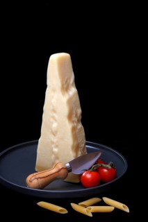 A piece of Parmesan cheese with cheese knife, pasta and tomatoes, Italy, Europe